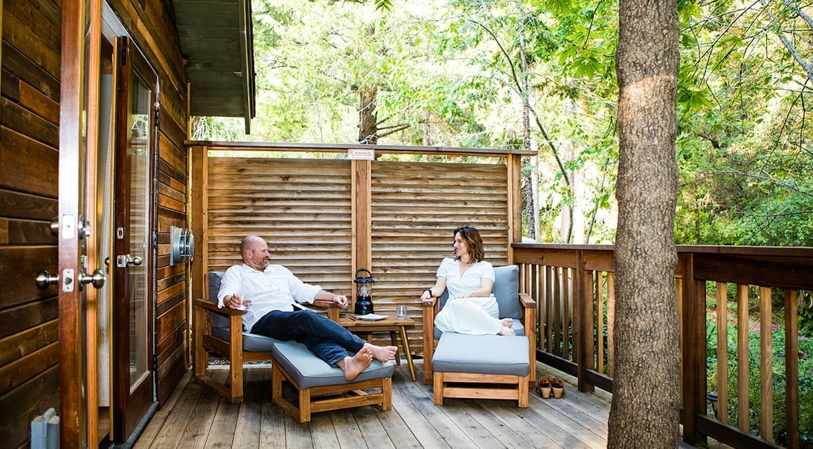 a couple laying on the terrace's chairs smiling at each other